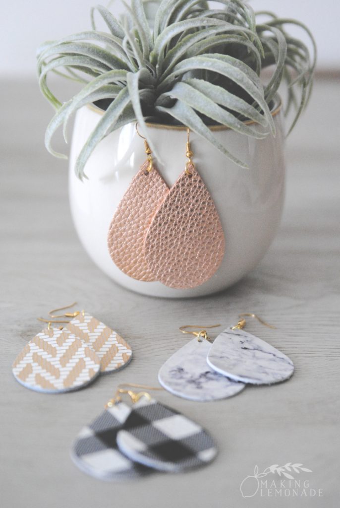 Rose gold leather earrings hanging on a potted plant 