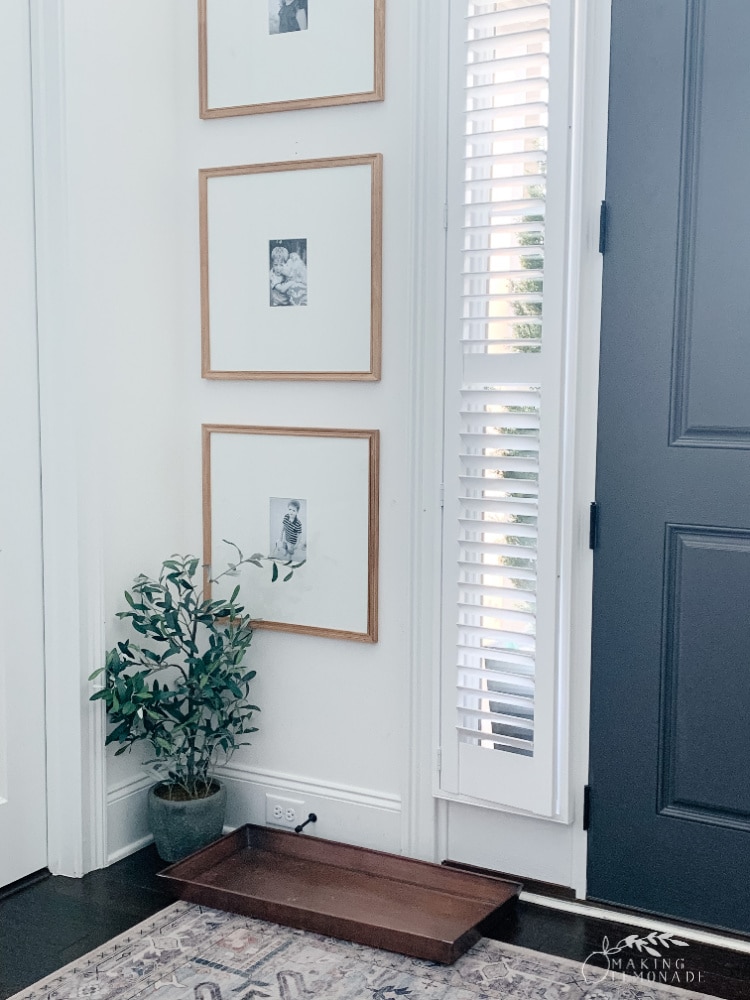 entryway with large frames on wall and boot tray