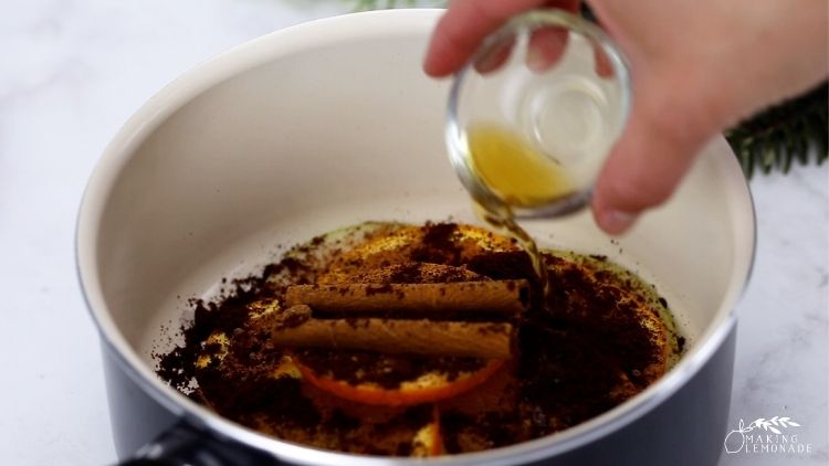 Adding vanilla to a saucepan to make a holiday simmer pot