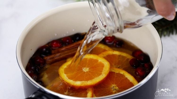 Pouring water into a DIY stovetop potpourri