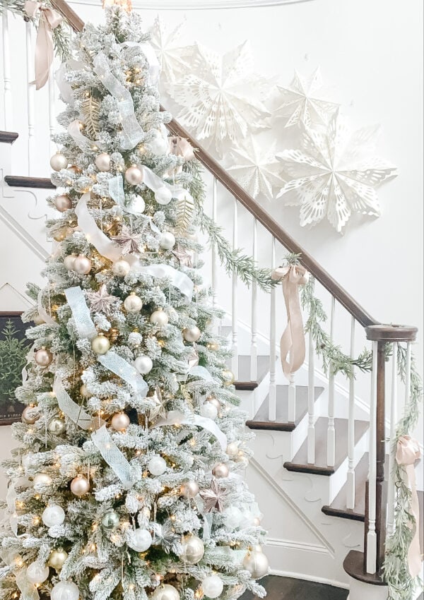 christmas tree by stairs with paper snowflakes