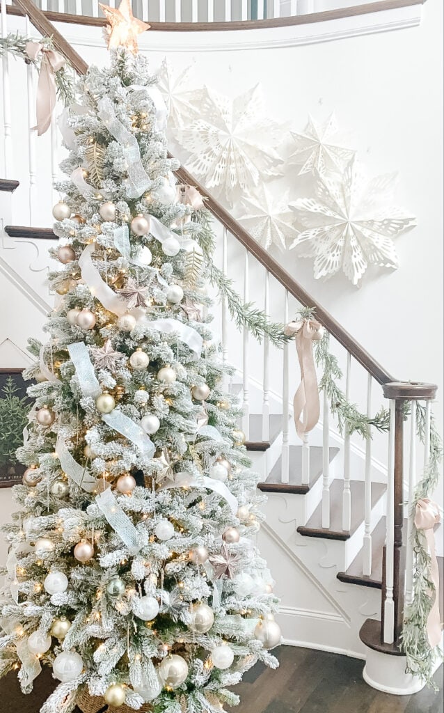 christmas tree by stairs with paper snowflakes