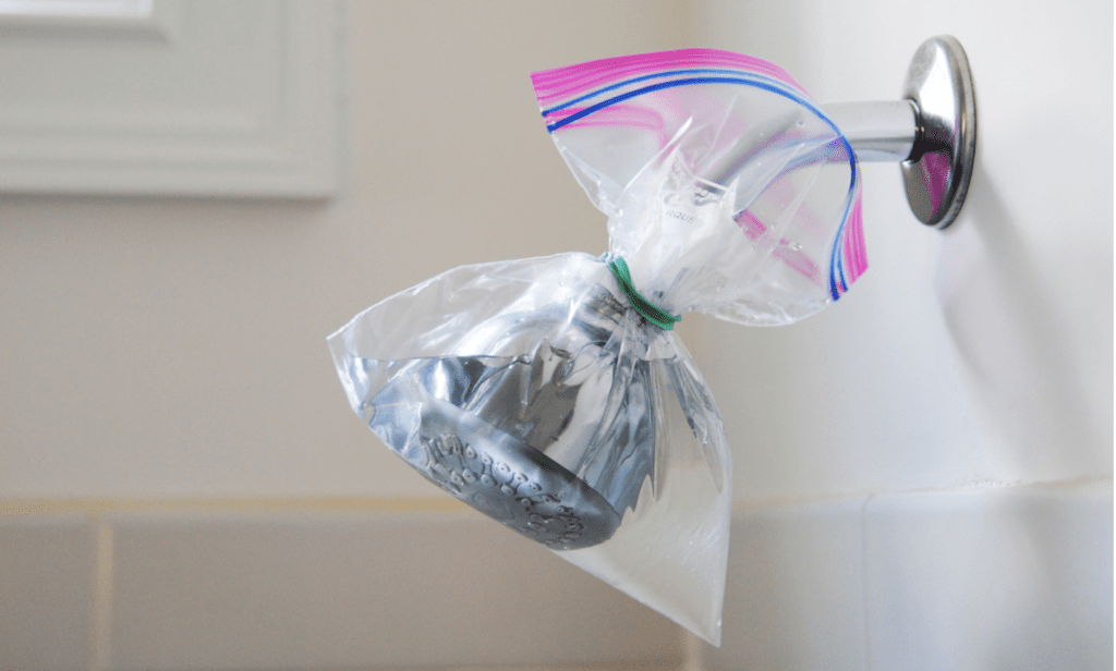 vinegar in a plastic bag being used to clean a shower head
