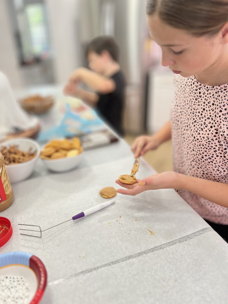 spreading the peanut butter on the crackers