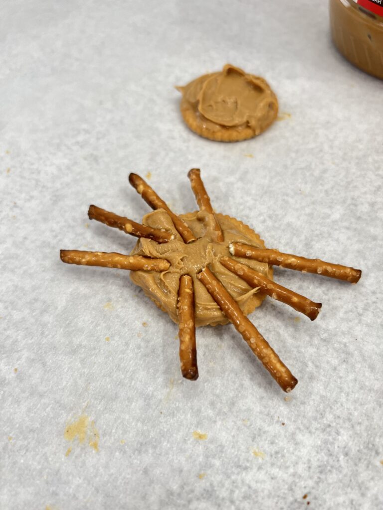 ritz cracker with peanut butter and pretzel sticks