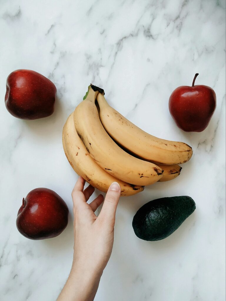 bananas, apples and avocado on the counter