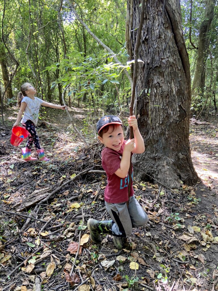 toddler swinging from vines on a tree