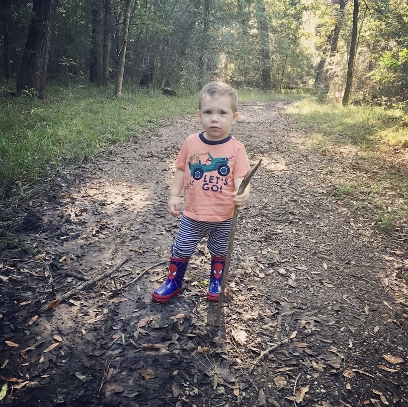 toddler on hiking trail with stick