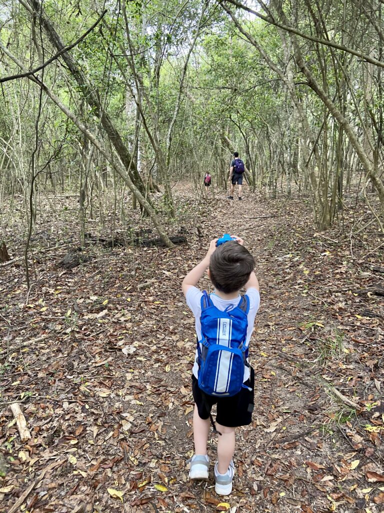toddler taking pictures in nature with a camera