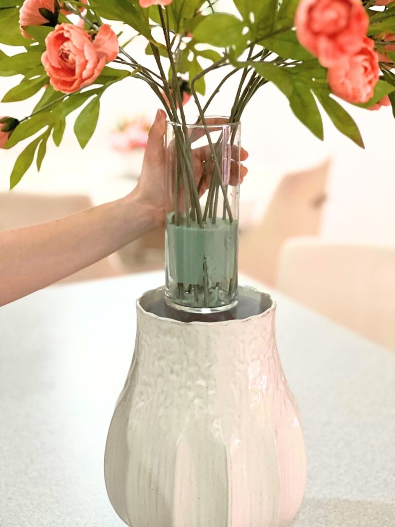arranging artificial flowers with vase inside a larger vase for stability and control of stems
