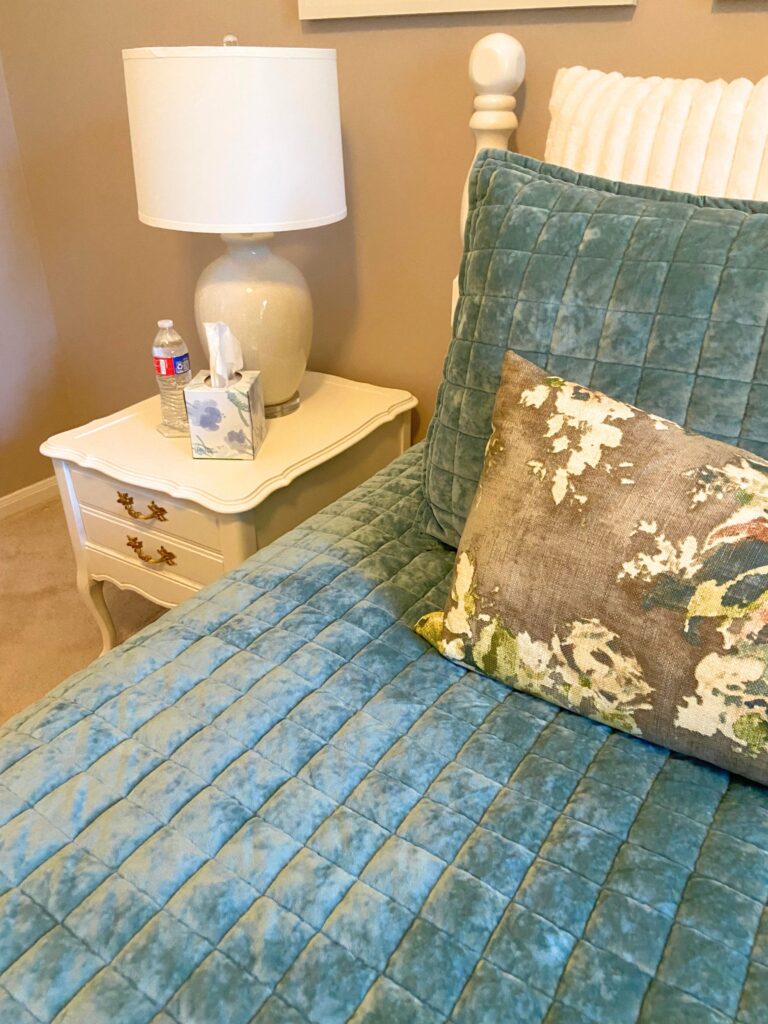 guest room essentials: nightstand with a bottle of water, lamp and tissue box for guest room