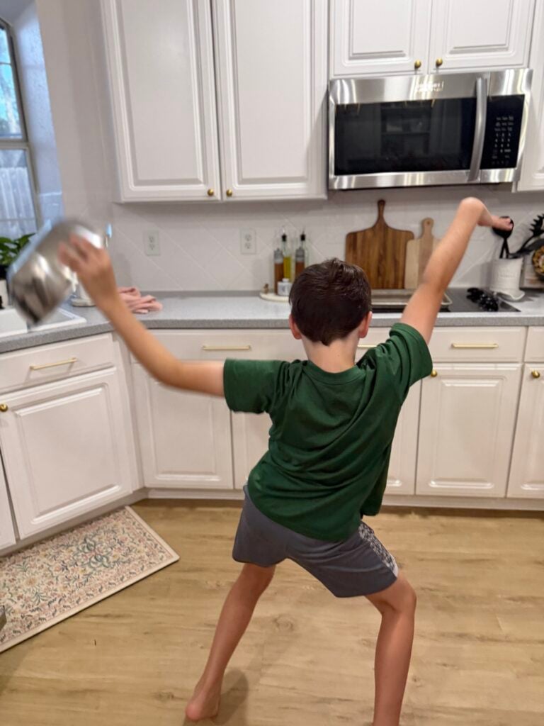 dancing with a bowl while unloading dishes